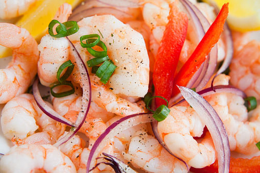 Seafood ceviche - king prawns, lemon, lime, juice, spring onions, chives and spicy chili red peppers. Traditional fresh dish from Peru, South America.