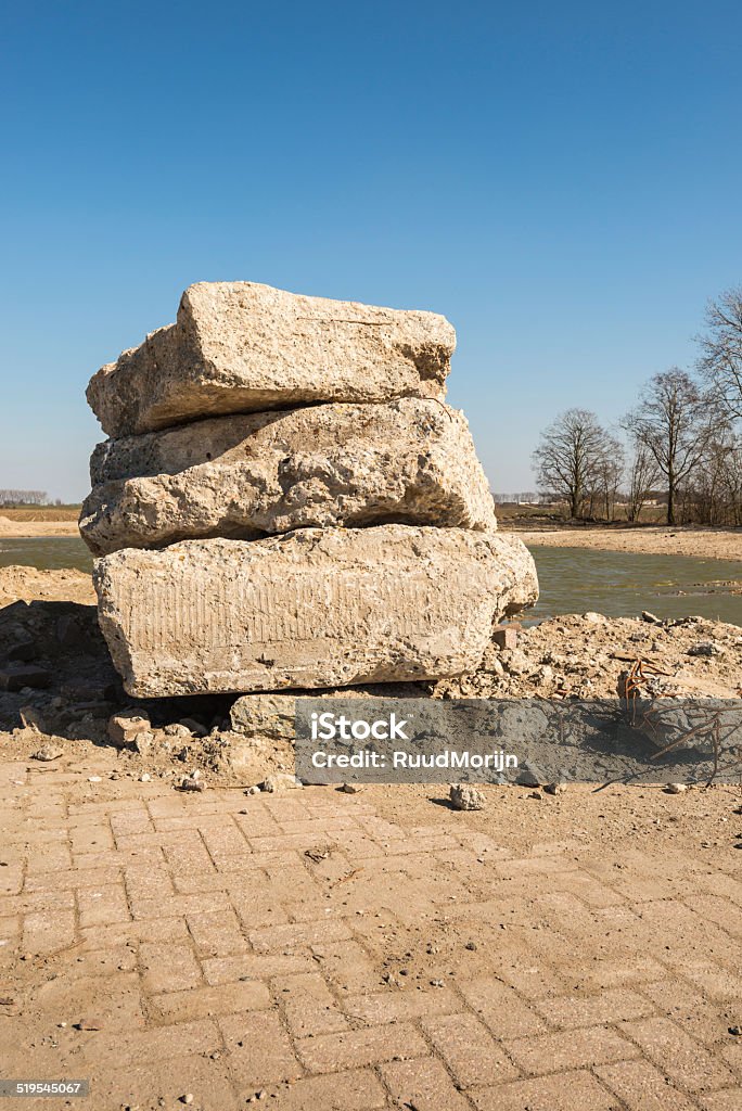 Large chunks concrete stacked Stacked chunks concrete and a pit filled with water after the demolition of a building in a rural setting. Abstract Stock Photo
