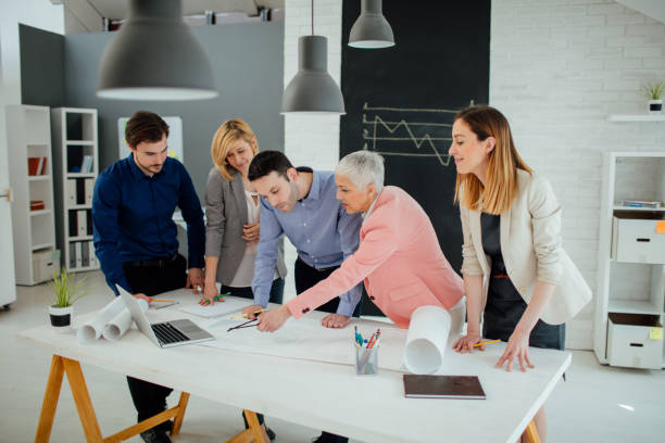 istock Team of architects reviewing blueprints in the office. 519545426