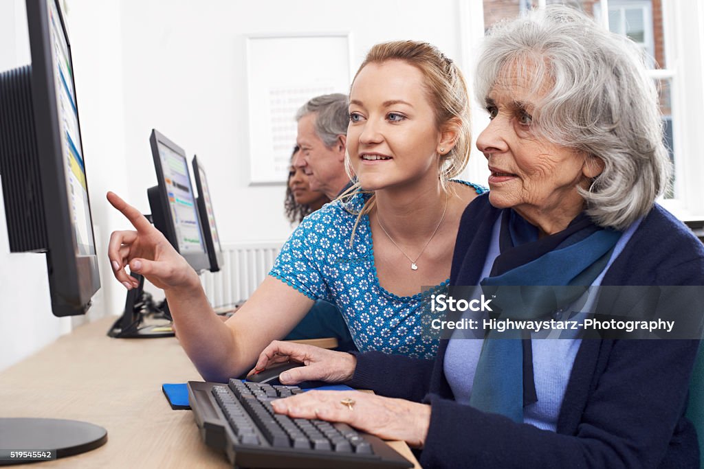 Tutor ajudando sênior mulher de computador classe - Foto de stock de Terceira idade royalty-free