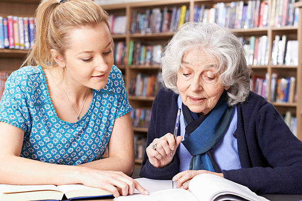 istock Senior Woman Working With Teacher In Library 519546072
