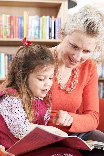istock Mother And Daughter Reading Book In Library 519547516