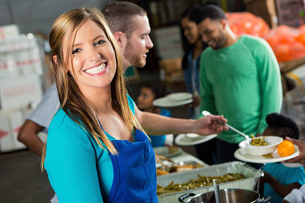 istock Pretty woman serving meal in soup kitchen 519547556