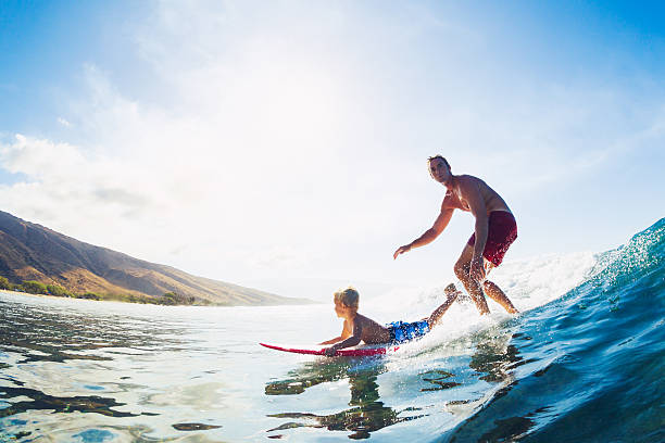 padre e hijo navegar, montar de forma de onda - surfing beach family father fotografías e imágenes de stock