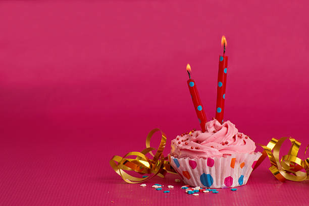 istock Delicious birthday cupcake on pink background 519548772