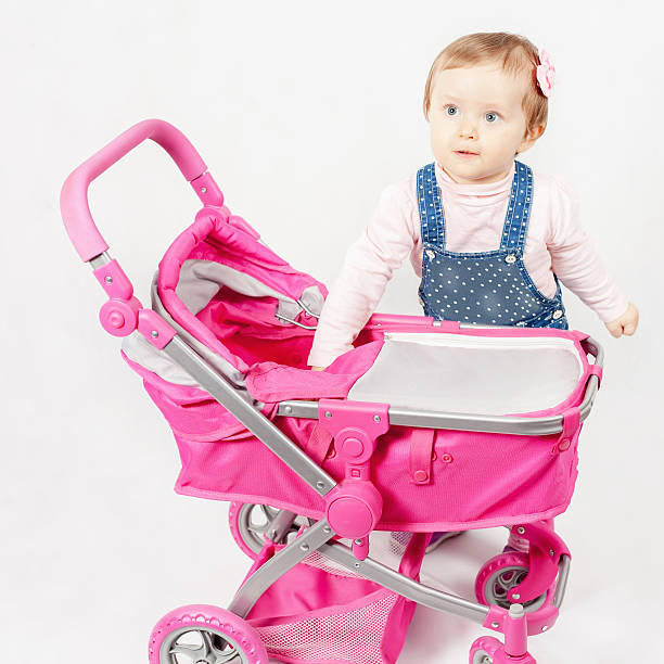 istock Cute little girl playing with baby stroller 519548820