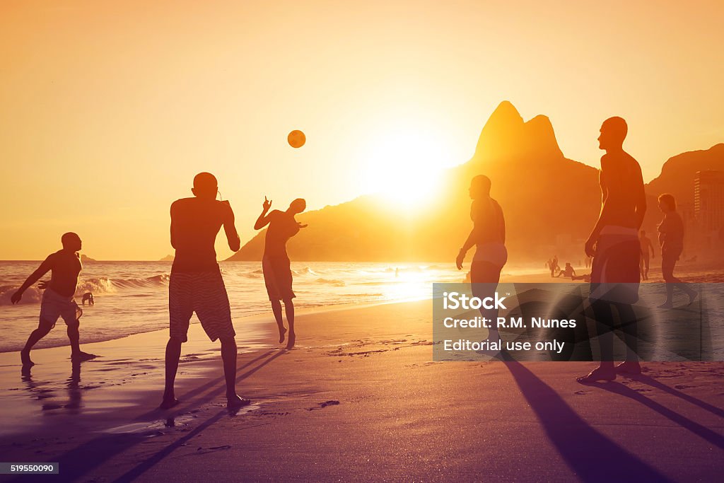 Locals Playing Ball in Ipanema Beach, Rio de Janeiro, Brazil Rio de Janeiro, Brazil - Circa February, 2016: Silhouette of locals playing ball at sunset in Ipanema beach, Rio de Janeiro, Brazil. Beach Stock Photo