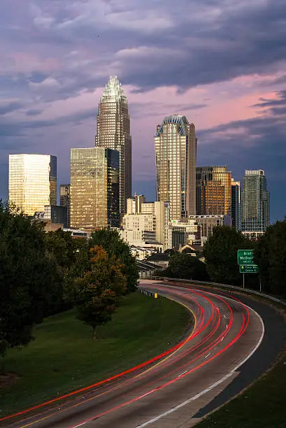 Rush hour in Charlotte, North Carolina during a colorful sunrise. The brake lights appear as streaks as cars make their way in to work. 