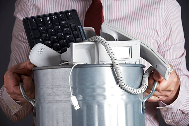 Businessman Holding Garbage Can With Obsolete Office Equipment Businessman Holding Garbage Can With Obsolete Office Equipment recycling computer electrical equipment obsolete stock pictures, royalty-free photos & images