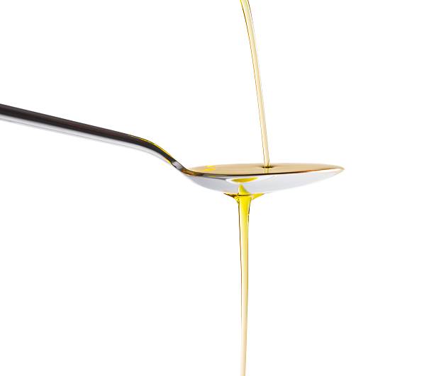 istock Extra virgin olive oil pouring over a spoon isolated 519551768