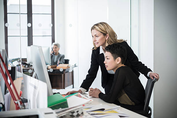 istock Female manager talking to young office worker at desk 519554538