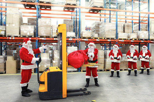 santa clauses in line for the sacks of gifts in storehouse 