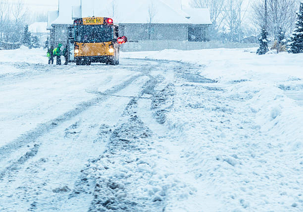 学校の学生搭乗ブリザード雪ストームスクールバス - road street sign slippery ストックフォトと画像