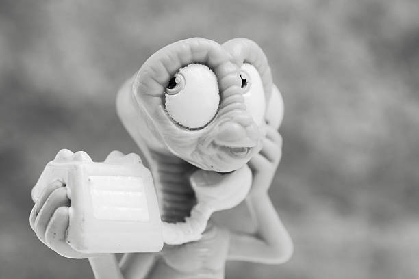 Fosston, USA - April 5, 2016: A vintage 1988 E.T. toy figurine talking on a telephone.  E.T. is a fictional character from the American science fiction family film, E.T. the Extra-Terrestrial.  The movie which was released on June 11, 1982 by Universal Pictures was co-produced and directed by Steven Spielberg and written by Steven Spielberg and Melissa Mathison.
