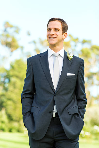 istock Groom Looking Away While Standing With Hands In Garden 519558669