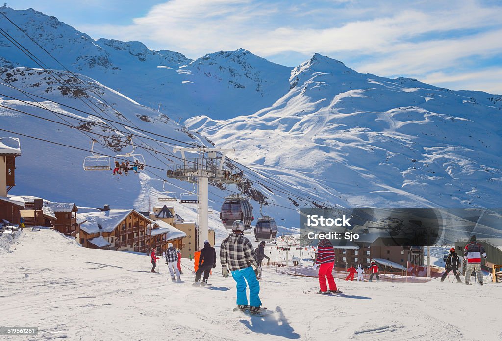 Ski Slope People skiing down a ski slope in the Trois Vallees skiing area in the French Alps on a beautiful winter day. French Alps Stock Photo