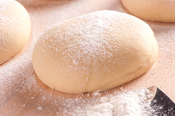 istock Fresh homemade pizza dough on floured wooden 519562177