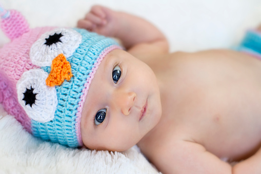 Baby girl with a knit owl hat.