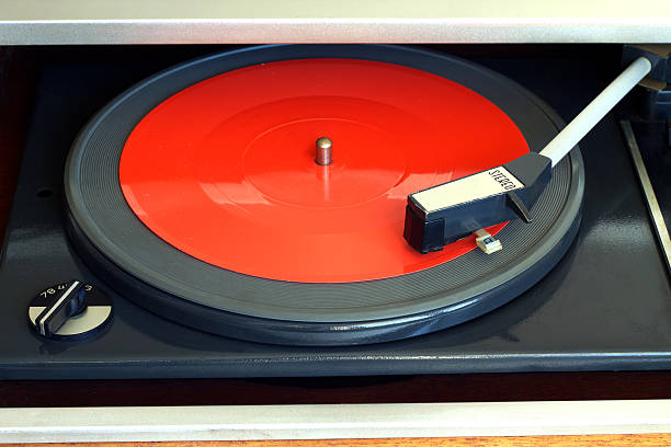 istock Vintage turntable with red red flexible disc closeup 519576418