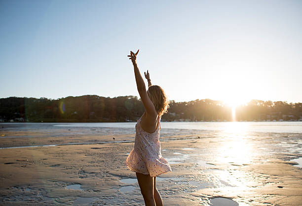 istock Girl on the beach dancing at sunset 519577476