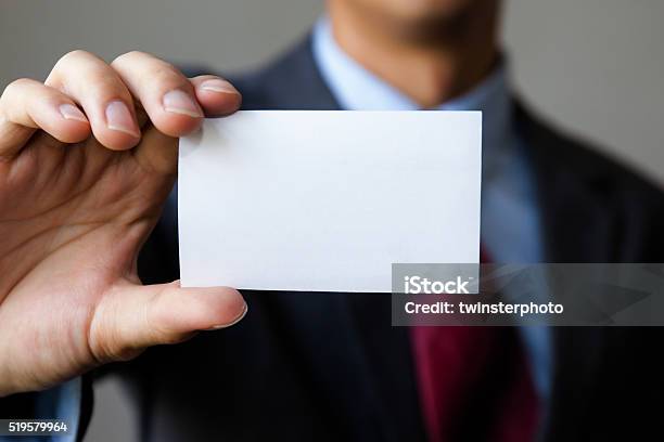 Young Man In Business Suit Holding White Blank Business Card Stock Photo - Download Image Now