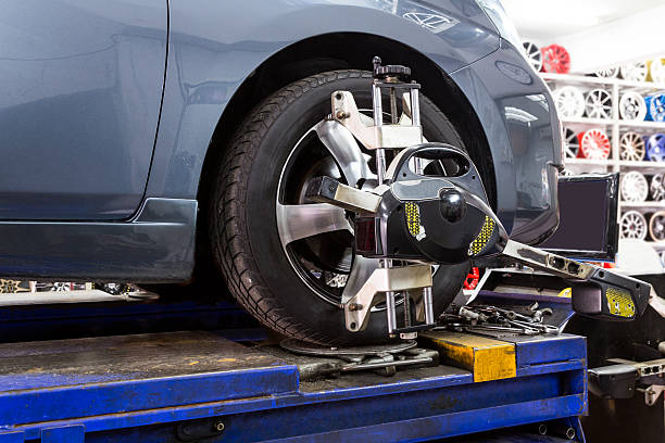istock Closeup of tire clamped with aligner undergoing auto wheel align 519581146