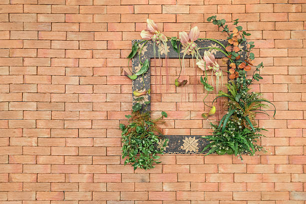фото рамка с цветами и декоративный растений на кирпичная стена - red poppies audio стоковые фото и изображения