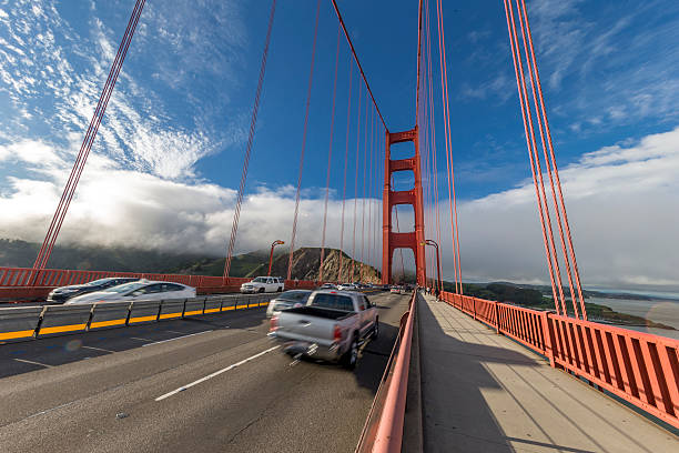 San Francisco, California, USA - March 19, 2016:  View under ultra wide angle,incidental people on the background, and traffic on the bridge.