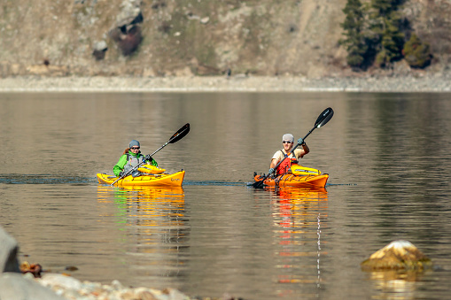 Bayview, Idaho USA - March 30, 2016: An editorial image of two kayakers paddling on Lake Pend Oreille in Idaho.