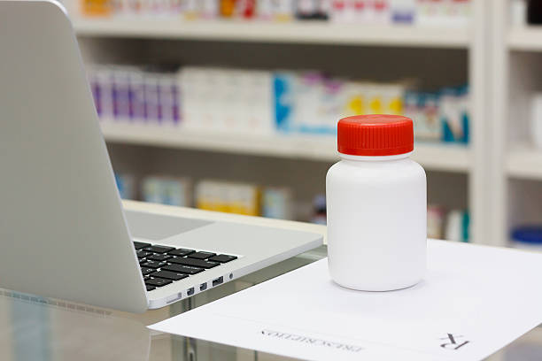 istock medicine bottle and laptop computer in the pharmacy 519586358