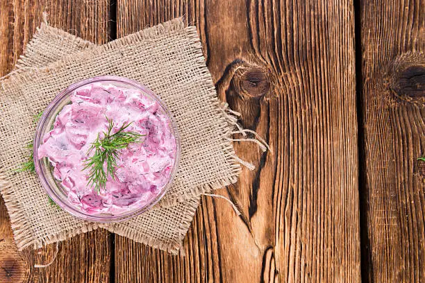 Homemade Herring Salad (close-up shot) on wooden background
