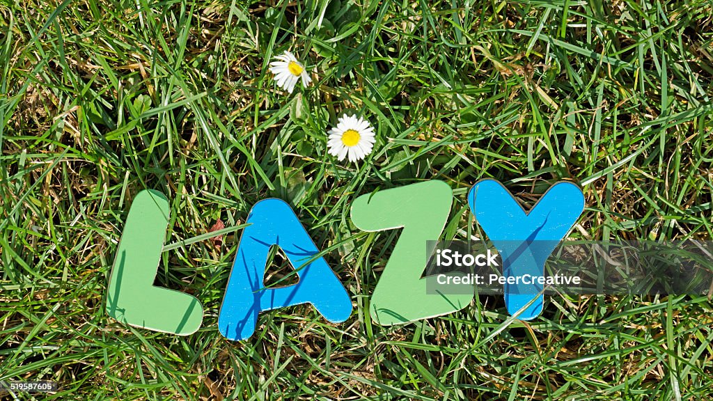 Lazy in the nature Lazy written with wooden letters in a sunny park. Grass Family Stock Photo