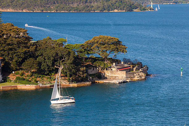 Sydney, Australia - April 14, 2011: A yacht seen passing by a bayside house in Sydney, Australia.