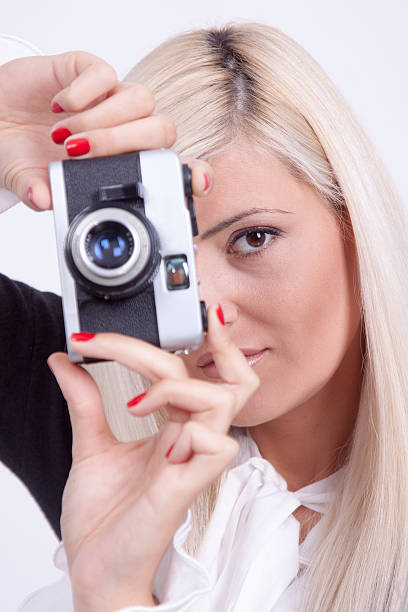 istock Blonde woman photographing over white background 519590577