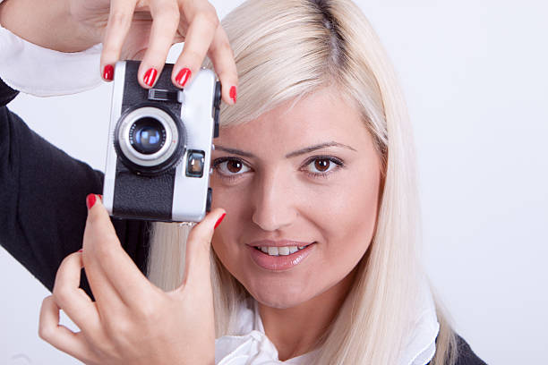 istock Blonde woman photographing over white background 519590601