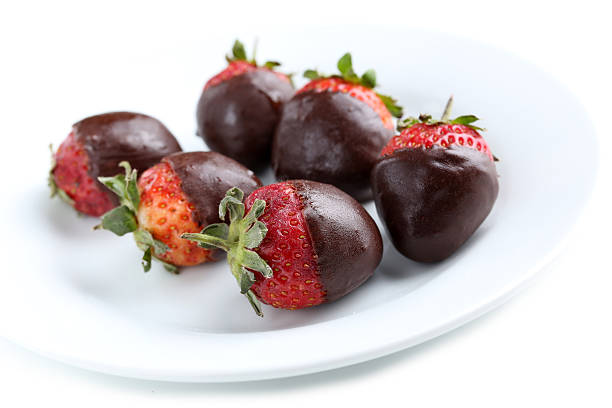 istock Fresh strawberries dipped in dark chocolate on white background 519609040