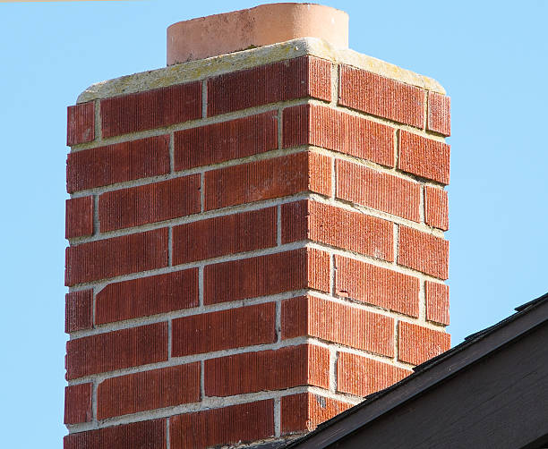 istock Brick Chimney on a Roof with a Blue Sky 519609828