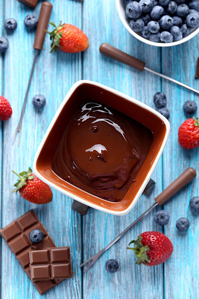 istock Chocolate fondue with fresh berries on a blue wooden table 519611678