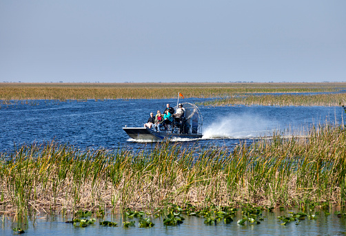 Weston, Florida, USA - February 13, 2016: Tourist enjoying and airboat ecotour of the Sawgrass Recreation Park in the Everglades . Sawgrass airboat tours are one of south Florida's top destinations activities for visitors to the state.