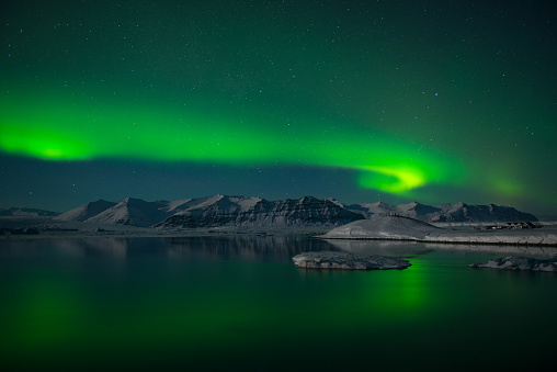Spectacular green Auroral display over the ice lagoon Jokulsarlon, at night, Iceland