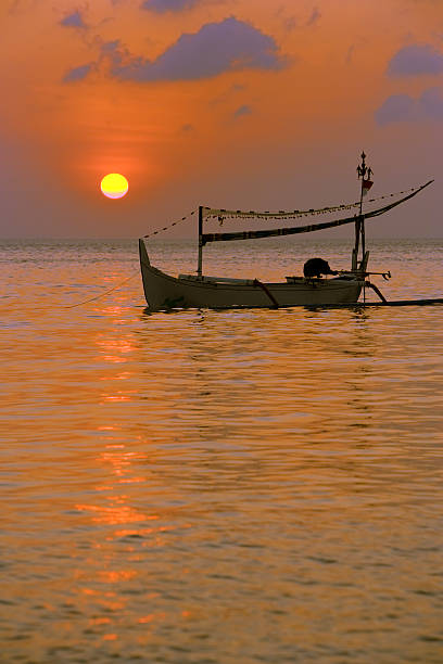 Boat is leaning on the sea in the sunset