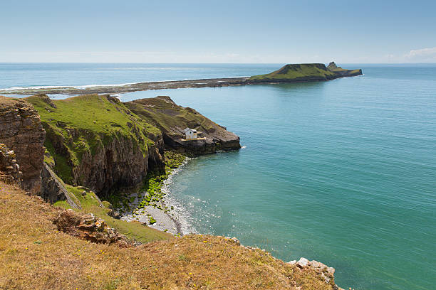 Worms Head Rhossili The Gower peninsula Wales UK island Worms Head Rhossili The Gower peninsula Wales UK small tidal island which you can walk to at low tide gower peninsular stock pictures, royalty-free photos & images