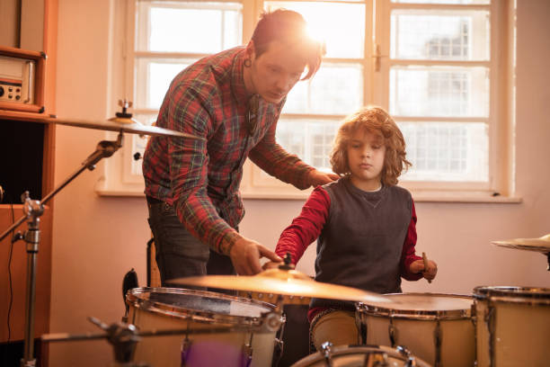 istock Father teaching his little boy how to play drums. 519615800