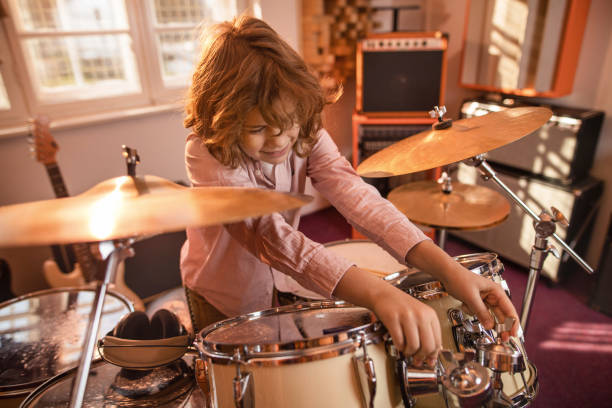 istock Little drummer adjusting drum kit in music studio. 519616782