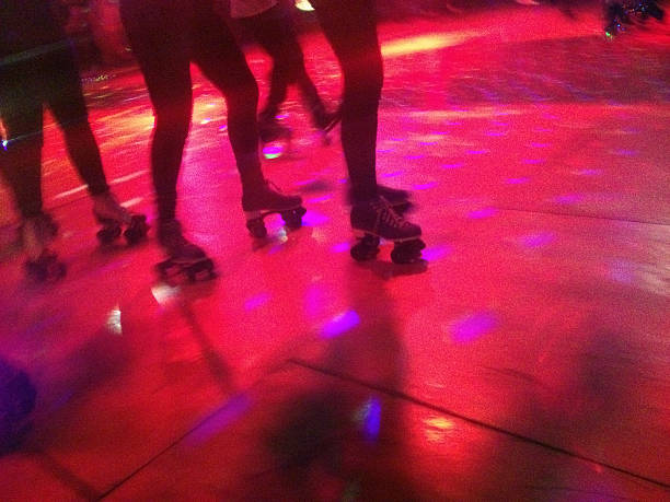 Roller Blade Disco Legs and roller skates on a lit dance floor of a roller disco. Shot with an iPhone. roller rink stock pictures, royalty-free photos & images