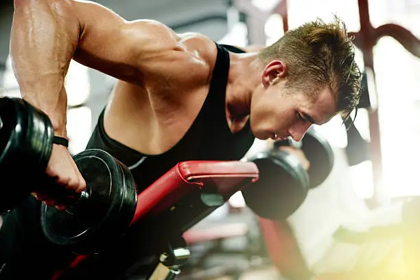 Shot of a young man working out at the gym