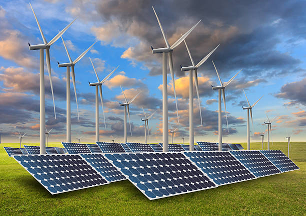 istock solar energy panels and wind turbine in sunset. 519620517