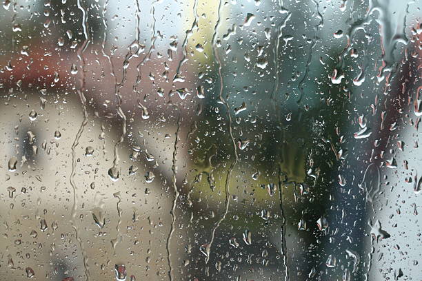 istock Rain drops on window with house and church in background 519620801