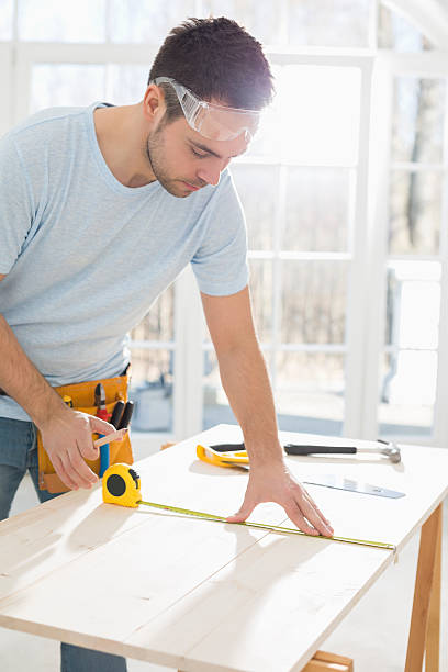 istock Mid-adult man marking table with measure tape 519620911