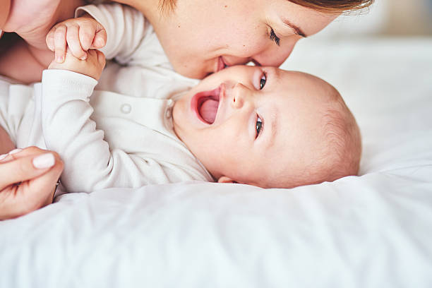 It’s cuddle time Shot of a young mother bonding with her adorable baby boy at home kissing stock pictures, royalty-free photos & images